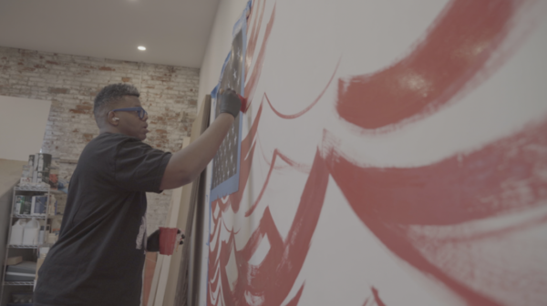 Gibson painting a large mural in progress